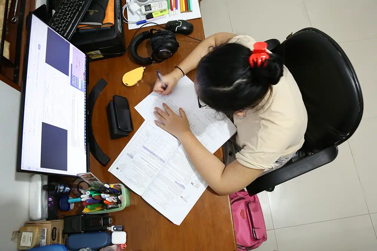 Materi belajar anak di meja dengan pulpen, buku, dan alat tulis